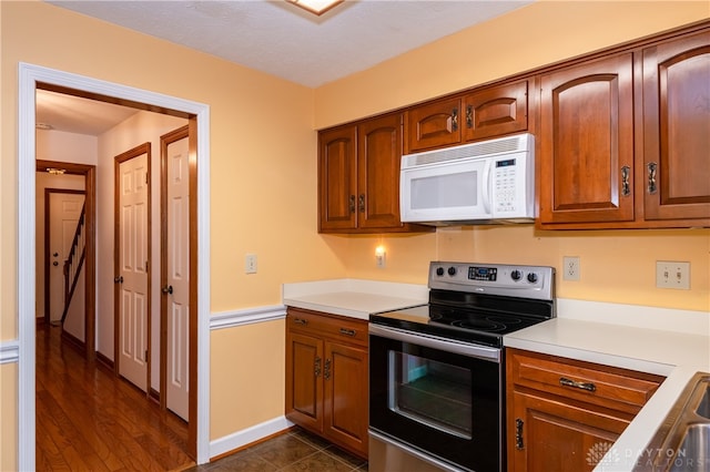 kitchen featuring a textured ceiling, dark hardwood / wood-style floors, and electric stove