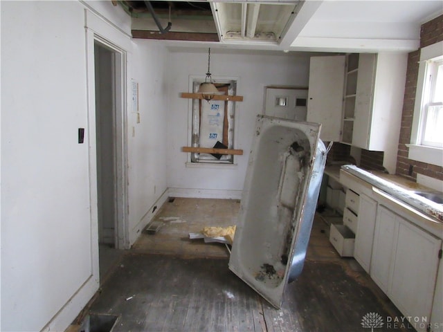 clothes washing area with dark wood-type flooring