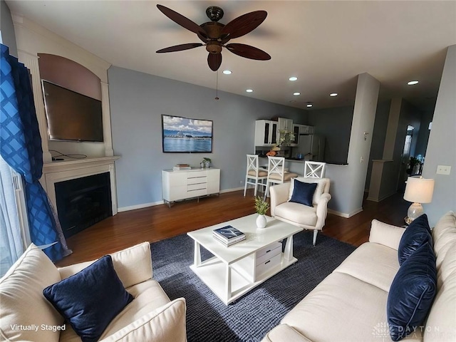 living room with dark wood-type flooring and ceiling fan