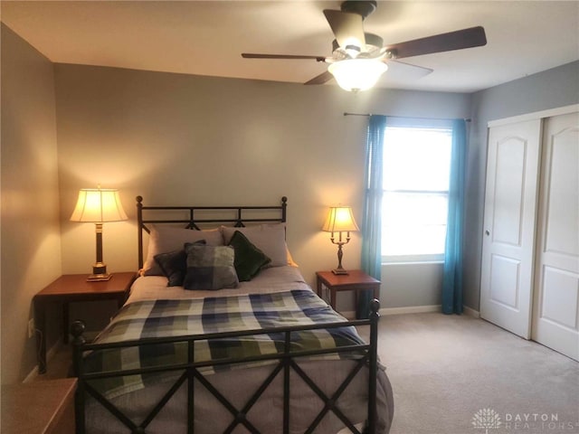 carpeted bedroom with ceiling fan and a closet