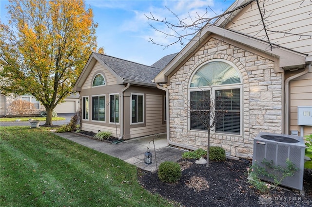 view of front facade with a patio area, a front yard, and central AC