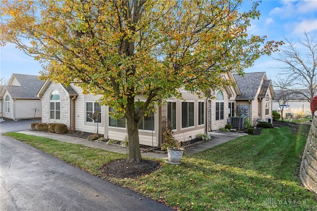 view of property exterior with central AC and a lawn