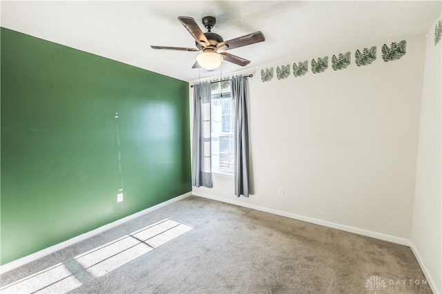 carpeted spare room featuring ceiling fan