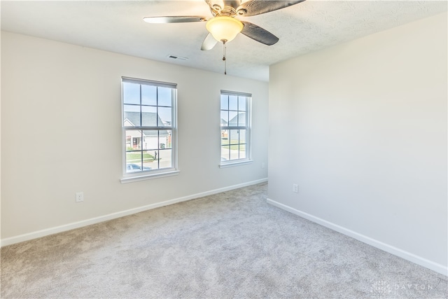 spare room featuring carpet flooring, a textured ceiling, and ceiling fan