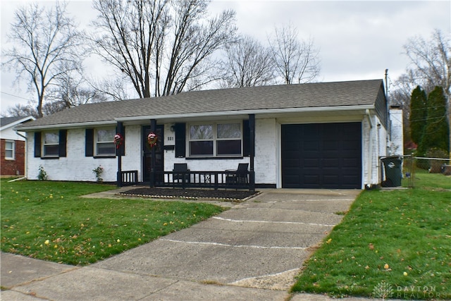 ranch-style home with covered porch, a front yard, and a garage