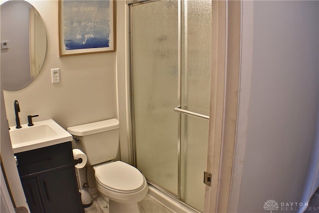 bathroom with vanity, a shower with shower door, and toilet