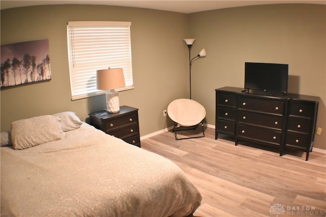 bedroom with light hardwood / wood-style floors and vaulted ceiling