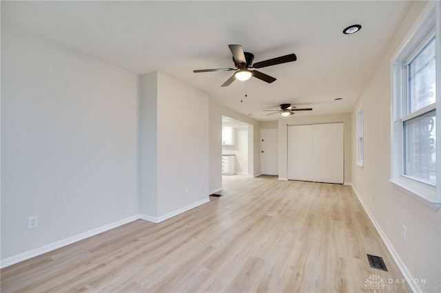 empty room with ceiling fan and light hardwood / wood-style flooring