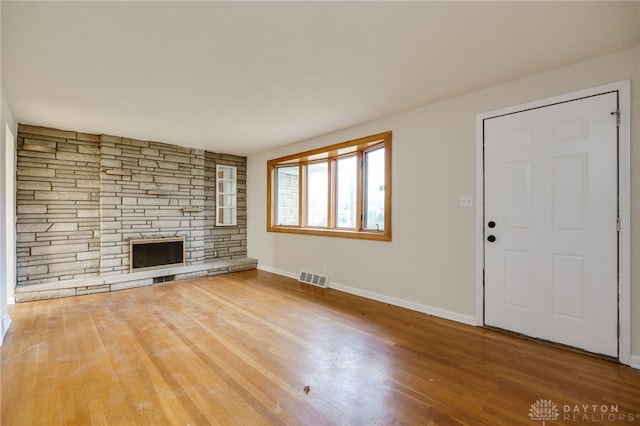 unfurnished living room featuring a fireplace and hardwood / wood-style floors