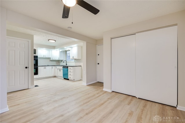 kitchen featuring white cabinetry, dishwasher, sink, double oven, and light hardwood / wood-style floors