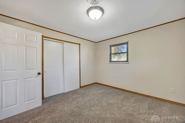 unfurnished bedroom featuring carpet, a closet, and crown molding