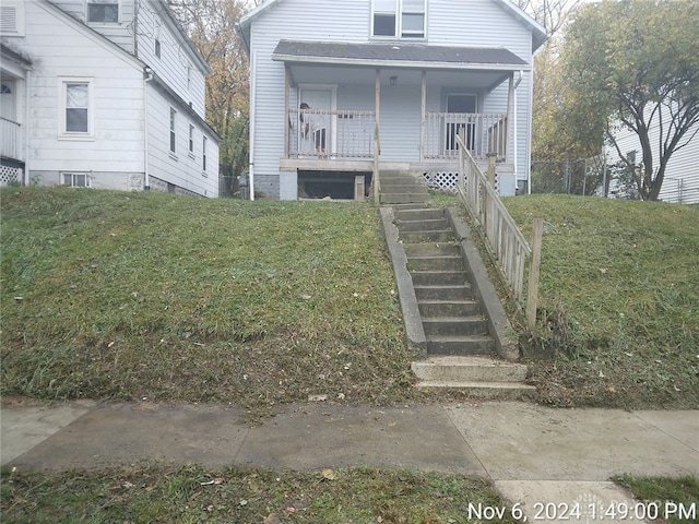 bungalow-style home with covered porch and a front lawn