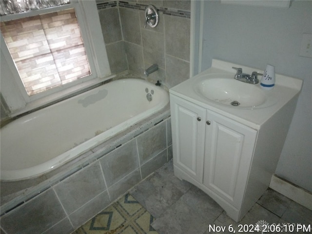 bathroom featuring vanity and a relaxing tiled tub