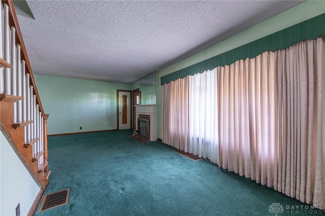 unfurnished living room with carpet floors and a textured ceiling