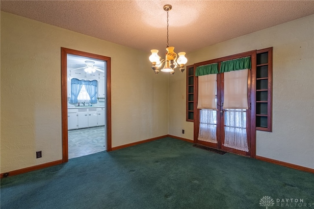 unfurnished room with french doors, dark carpet, and a textured ceiling