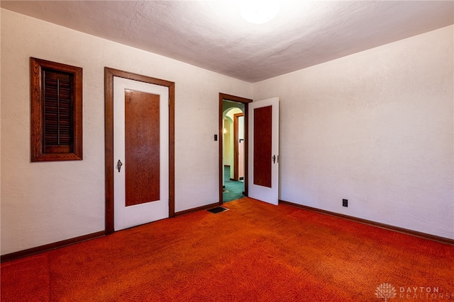 unfurnished bedroom with carpet floors and a textured ceiling