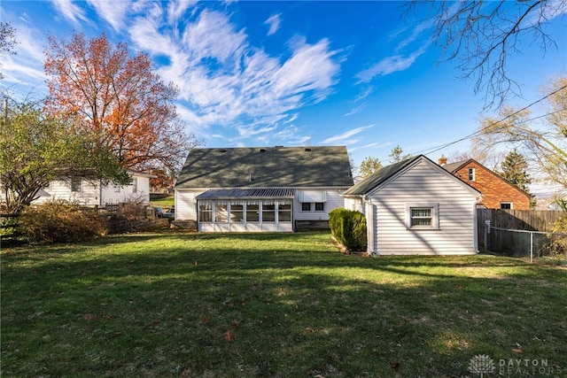 rear view of house with a sunroom and a lawn