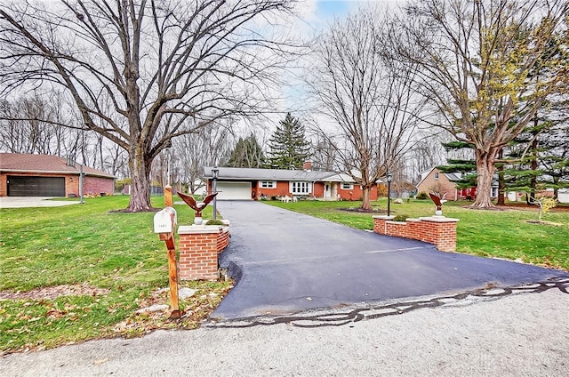 ranch-style house featuring a garage and a front lawn