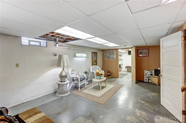 basement with a drop ceiling and a wealth of natural light