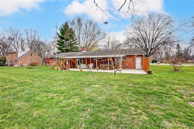 rear view of property with a patio area and a yard