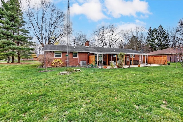 back of property with a yard, central AC, and a patio area