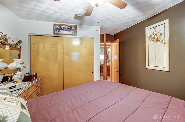 bedroom with ceiling fan and a closet