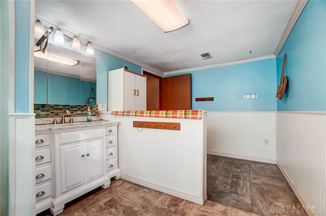 bathroom featuring decorative backsplash, vanity, and ornamental molding