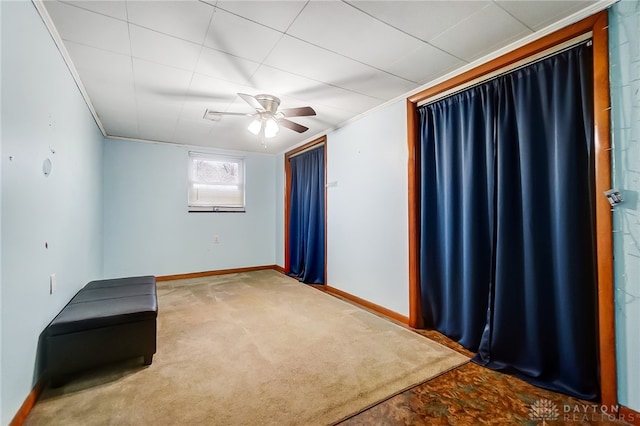 carpeted spare room with ceiling fan and ornamental molding