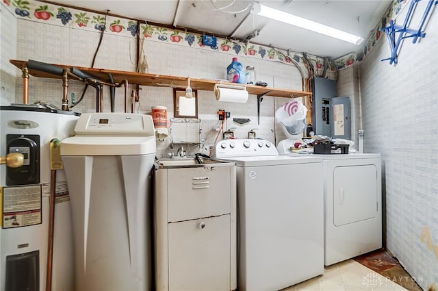 laundry area with electric panel, water heater, and washer and dryer