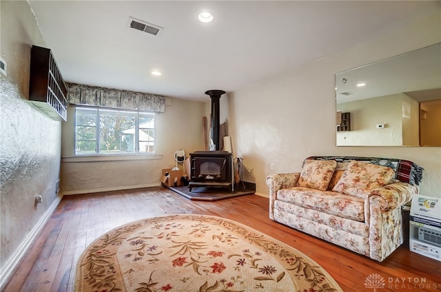 living room featuring a wood stove and hardwood / wood-style floors