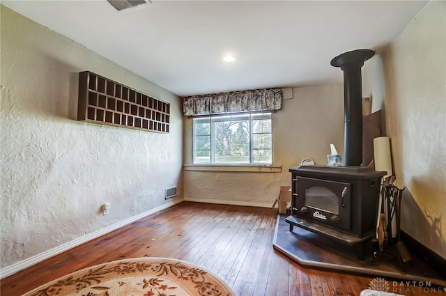 interior space featuring a wood stove and hardwood / wood-style floors