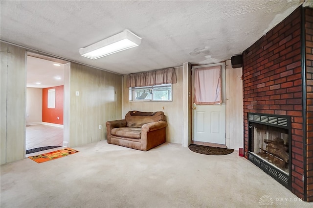 living area featuring carpet flooring, a textured ceiling, and a brick fireplace