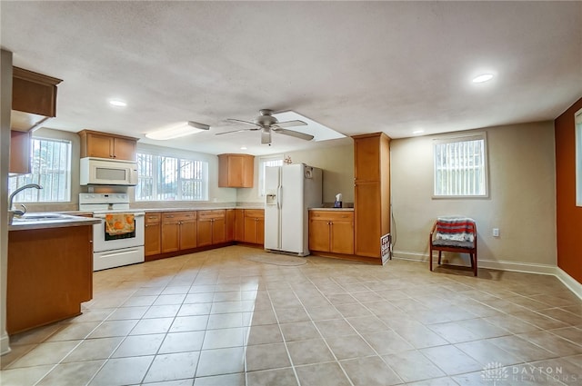 kitchen featuring ceiling fan, white appliances, sink, and light tile patterned floors