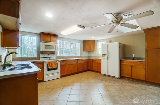 kitchen featuring light tile patterned flooring, white appliances, ceiling fan, and sink