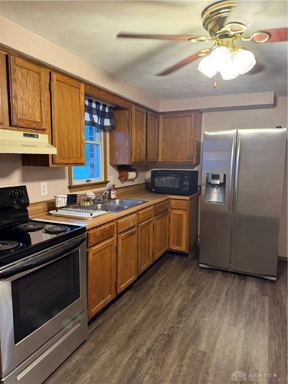 kitchen with appliances with stainless steel finishes, ceiling fan, dark wood-type flooring, and sink