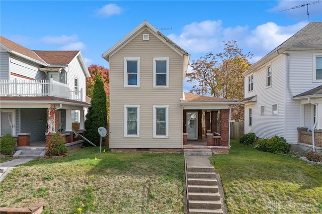 front facade featuring a porch, a balcony, and a front lawn