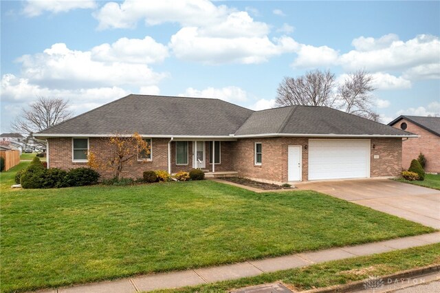 ranch-style home with a garage and a front lawn