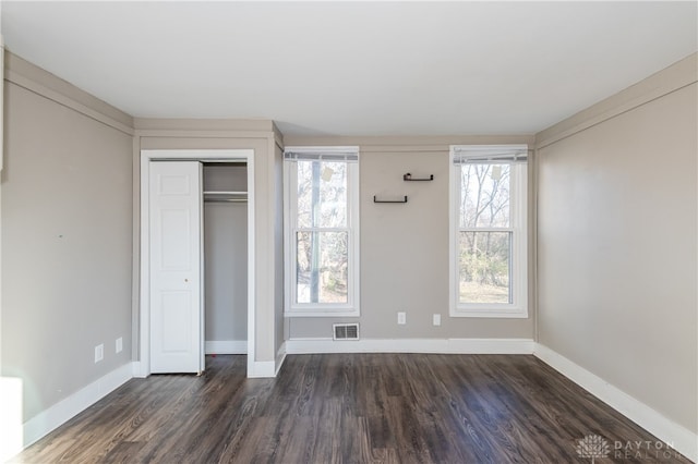 unfurnished bedroom featuring a closet and dark wood-type flooring