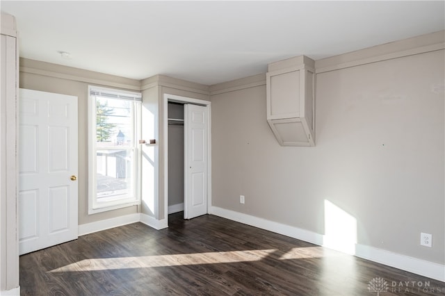 unfurnished bedroom featuring dark hardwood / wood-style flooring and a closet