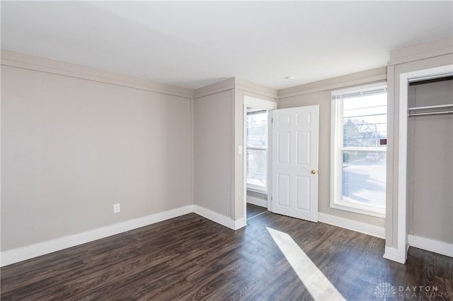 unfurnished bedroom with a closet and dark wood-type flooring