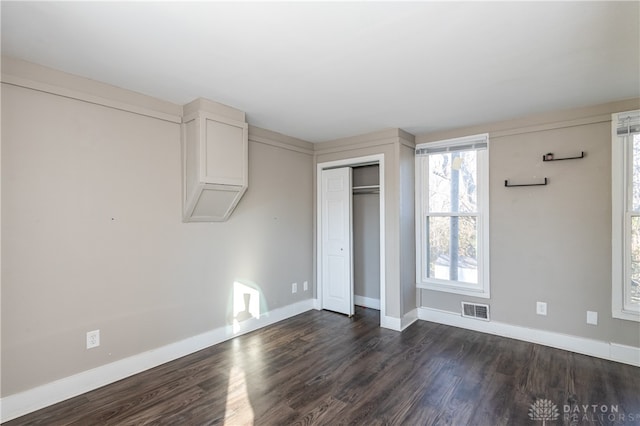 unfurnished bedroom with a closet and dark wood-type flooring