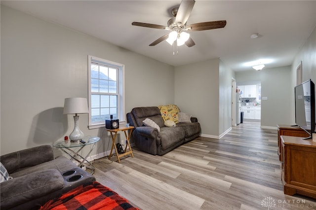 living room featuring ceiling fan and light hardwood / wood-style floors