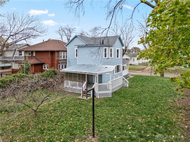 rear view of house featuring a lawn and a wooden deck