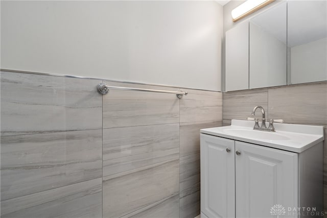 bathroom featuring vanity and tile walls