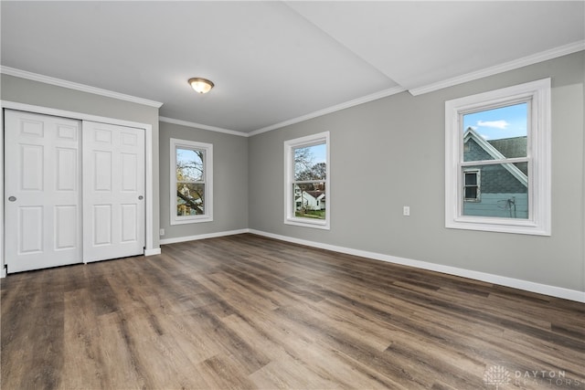 unfurnished bedroom with multiple windows, crown molding, and wood-type flooring