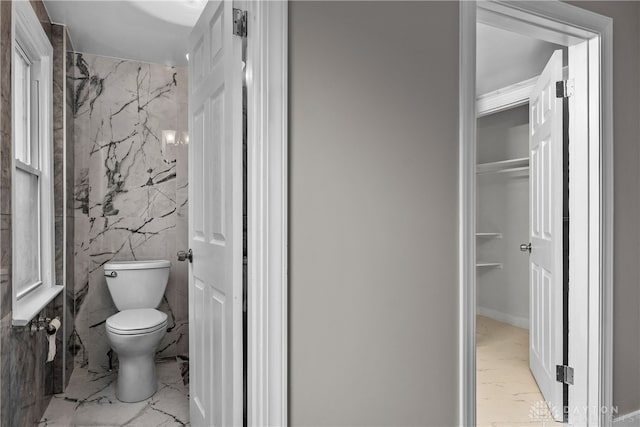 bathroom with tile walls and toilet