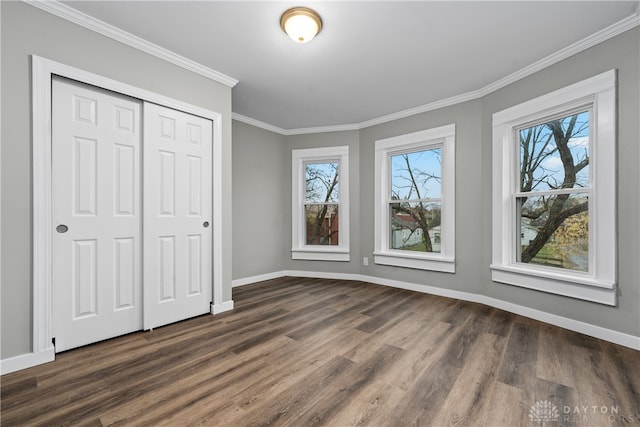 unfurnished bedroom featuring dark hardwood / wood-style floors, a closet, and ornamental molding