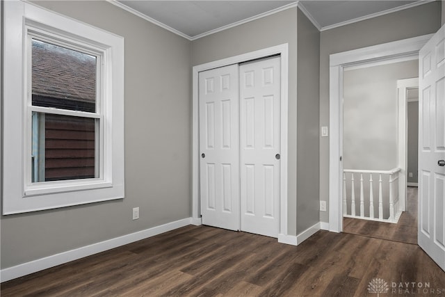 unfurnished bedroom featuring crown molding, a closet, and dark wood-type flooring