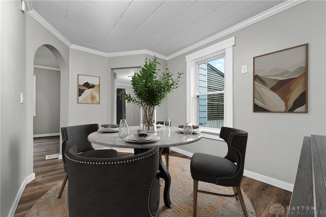 dining room with crown molding and dark hardwood / wood-style flooring