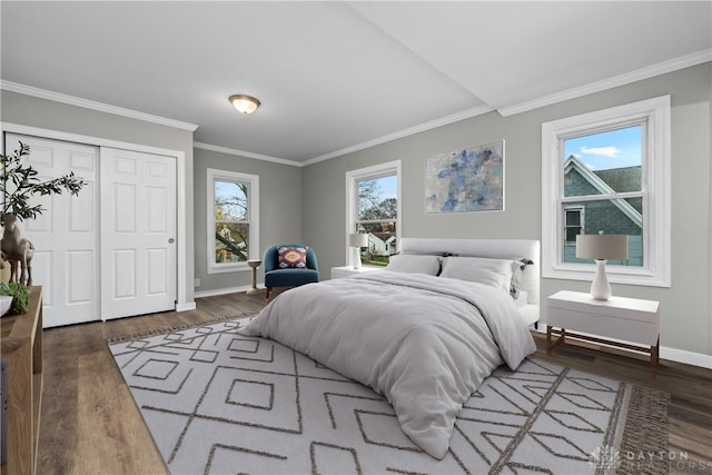 bedroom with dark hardwood / wood-style floors, crown molding, and a closet